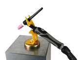 Yellow magnetic holder supporting a TIG torch on a steel surface